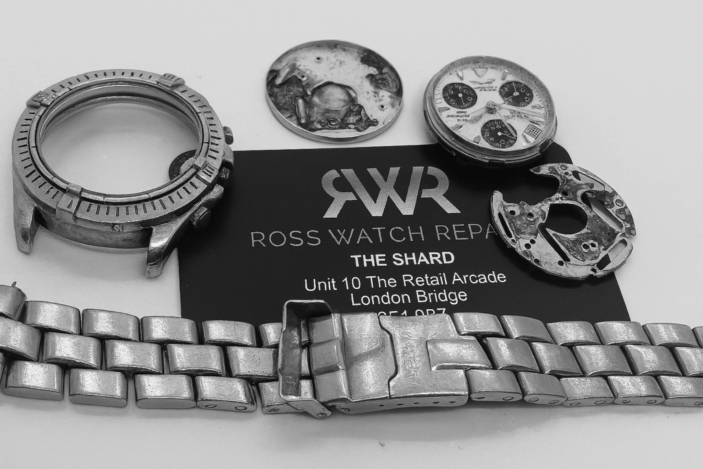 Disassembled watch parts laid out on an RWR business card at The Shard, London — ideal candidate for Mini Service
