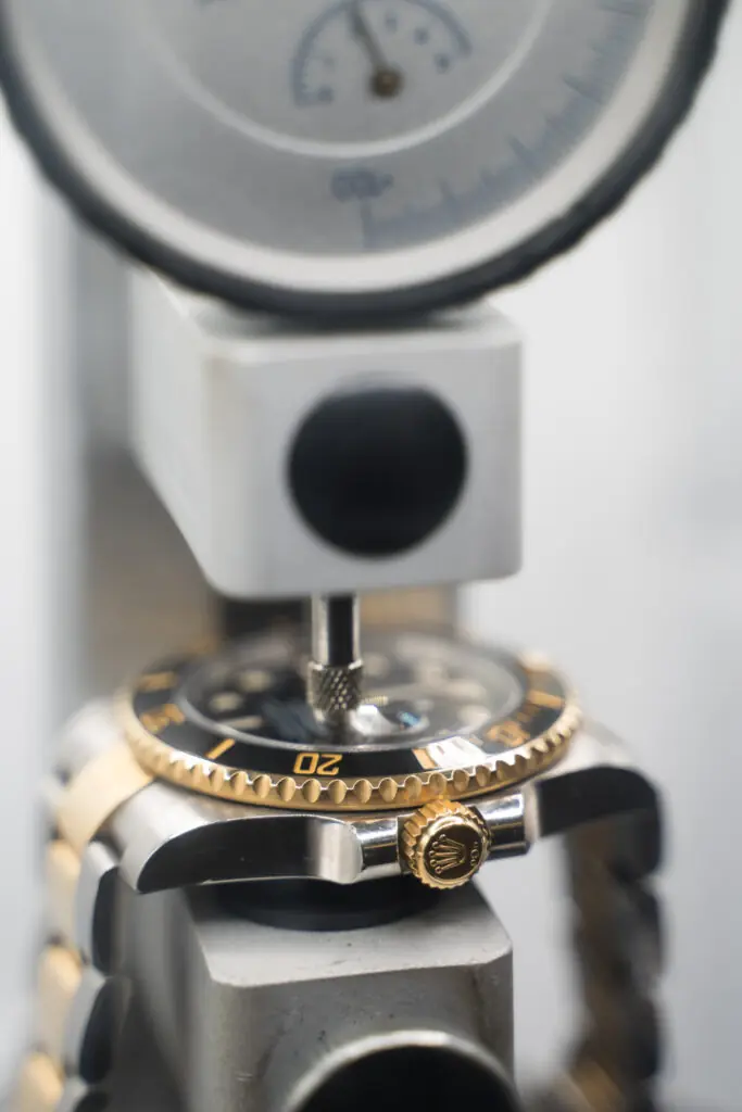Luxury dive watch undergoing pressure testing after battery replacement and reseal.