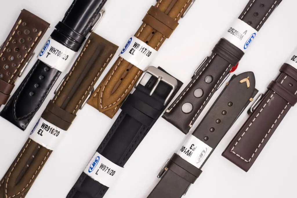 A selection of leather watch straps laid diagonally on a white background, showcasing various styles and colours—ideal for watch strap replacement services.