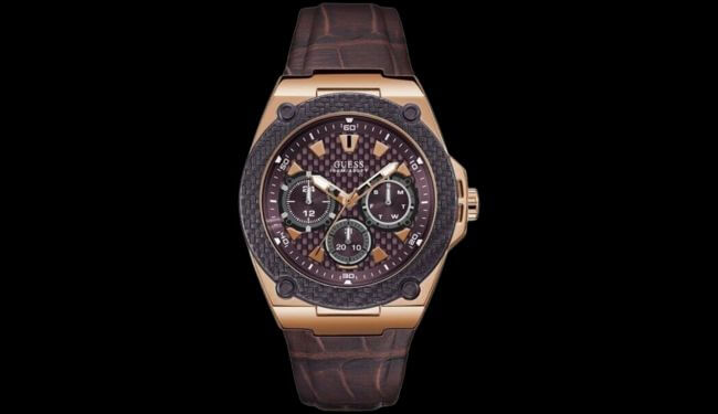Guess watch with a dark dial and brown strap photographed on a black background