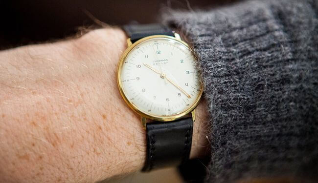 Junghans-style watch on wrist with white dial and black leather strap – junghans watch repair