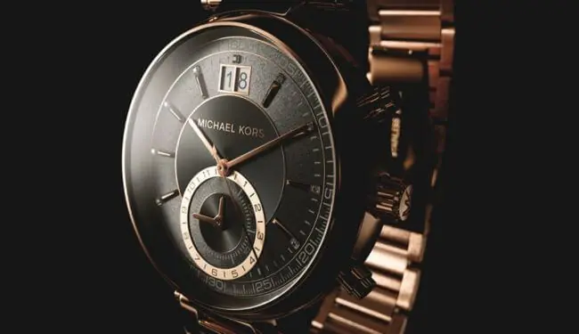 Close-up of Michael Kors-style watch face with gold bracelet on dark background – michael kors watch repairs