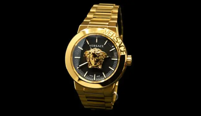 Gold Versace wristwatch on a black background for Versace watch repairs.