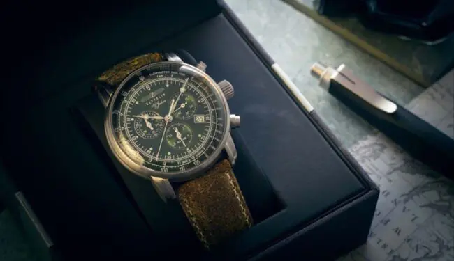 Zeppelin wristwatch on a presentation box beside a pen on a desk.