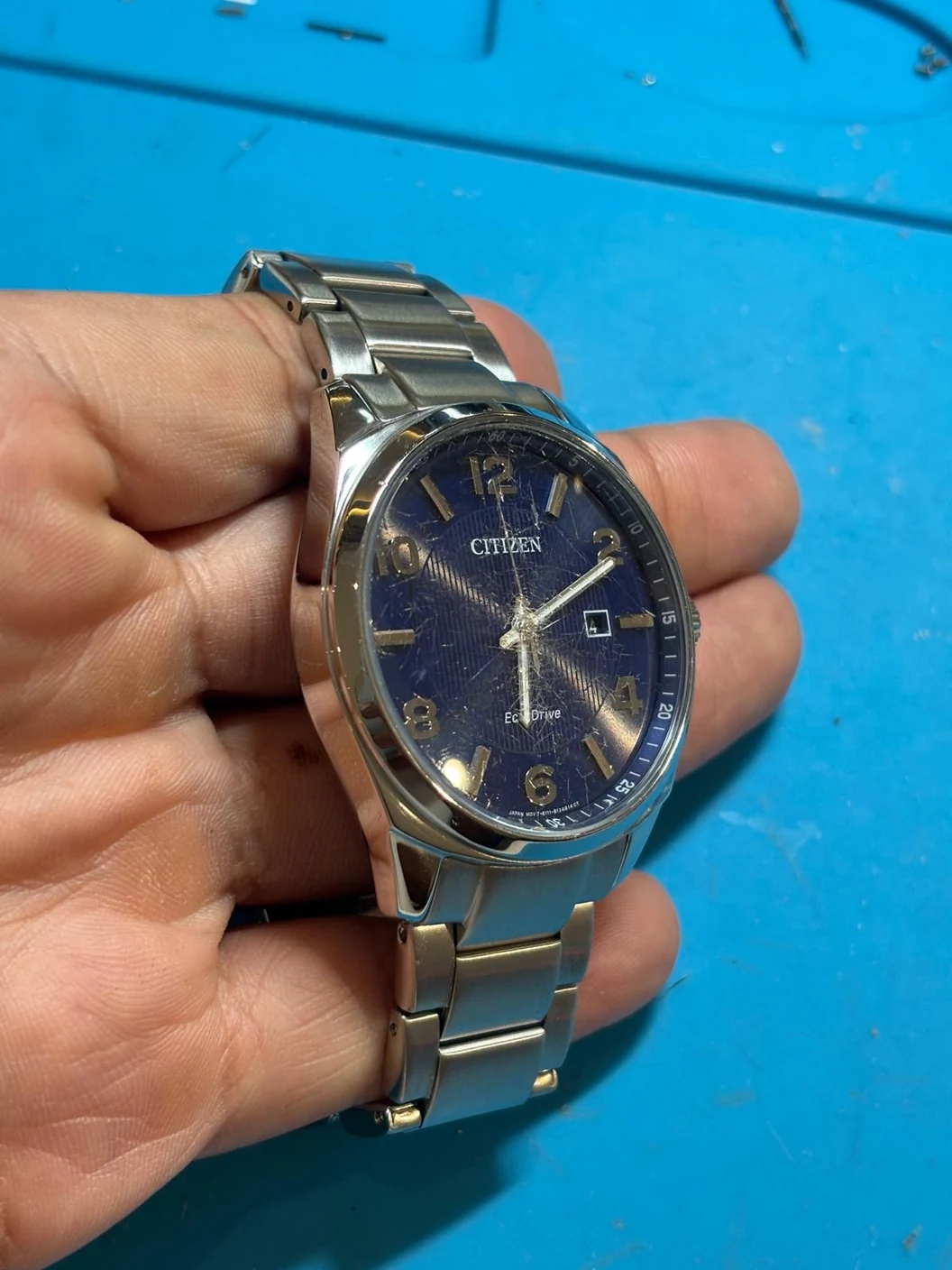 Angled view after the Citizen repair, showing polished metalwork and the original scratched glass