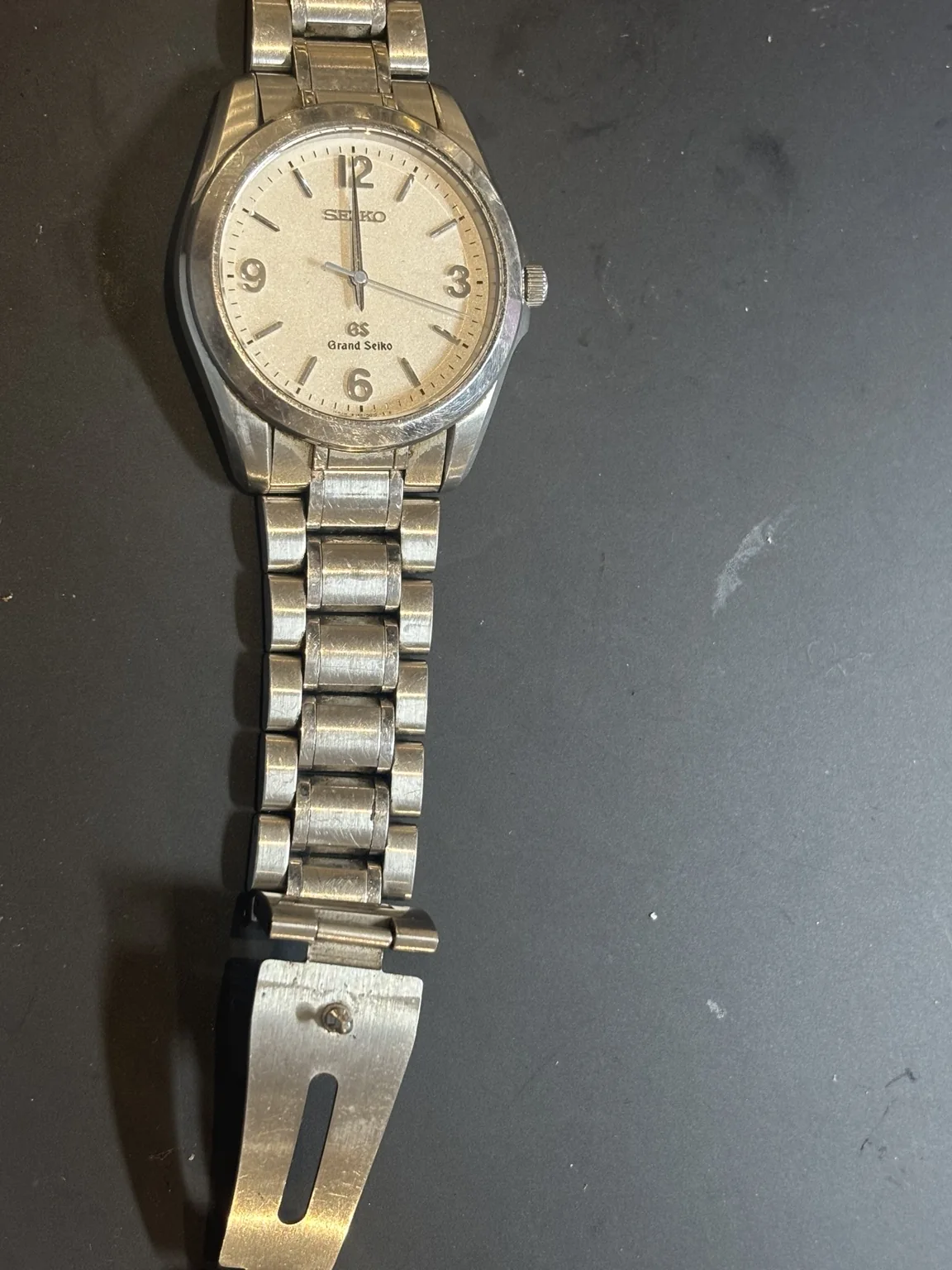 Grand Seiko 8J55-0010 before Mini Service showing a scratched case and stainless steel bracelet